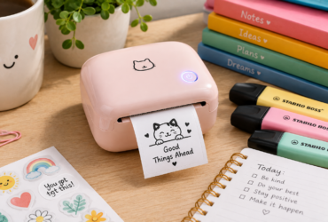 Mini pocket printer drukt een sticker af op een bureau